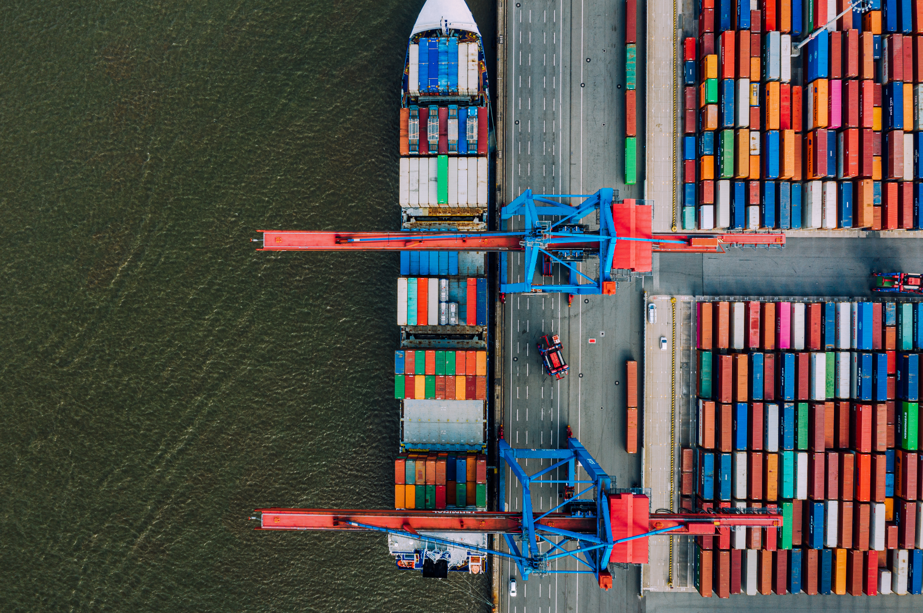 Aerial view of a container port with colourful shipping containers and cranes